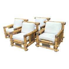 three chairs made out of bamboo with white cushions