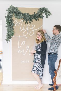 a man and woman standing next to each other in front of a sign that says miss to mrs