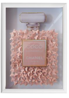 a chanel perfume bottle with pink butterflies on the front and bottom, in a white frame