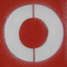 a red and white circle painted on the side of a building