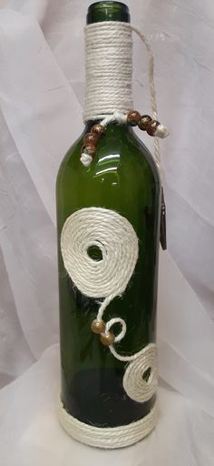 a green glass bottle with white rope wrapped around it