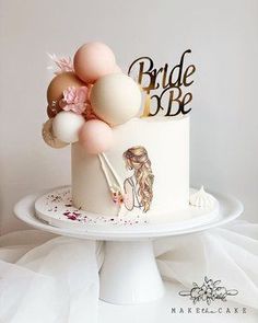 a white wedding cake with balloons and bride's name on the top is sitting on a pedestal