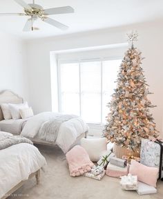 a bedroom decorated for christmas with a tree in the corner