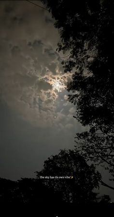 the full moon shines brightly through the clouds in the night sky above some trees