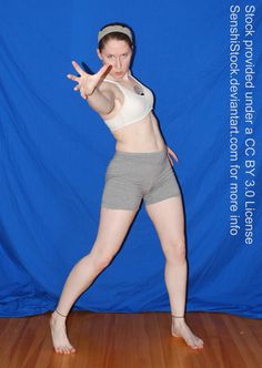 a woman is posing in front of a blue backdrop with her hand up to the side