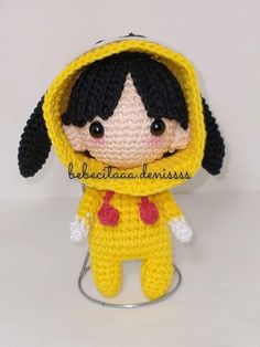 a crocheted doll wearing a yellow raincoat