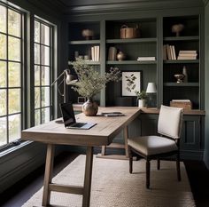 a home office with built in bookshelves, desk and chair by the window