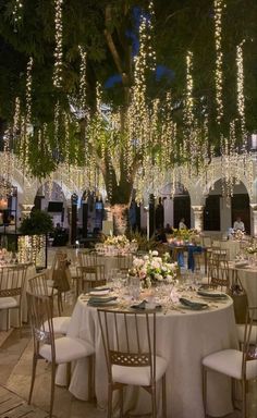 an image of a table set up for a wedding reception with lights hanging from the ceiling