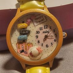 a close up of a wrist watch on a table with a pink and yellow background