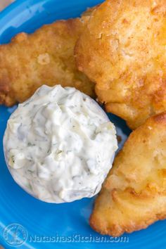 some fried food on a blue plate with a dollop of sour cream in the middle