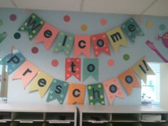 a welcome to preschool banner hanging from the ceiling in an office area with desks