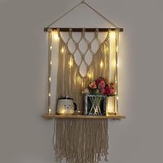 a shelf with some lights hanging from it's sides and a vase on top