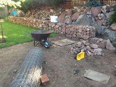 there is a fire pit in the middle of this yard that has rocks and gravel around it