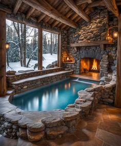 an indoor swimming pool surrounded by stone walls and windows, with a fireplace in the corner