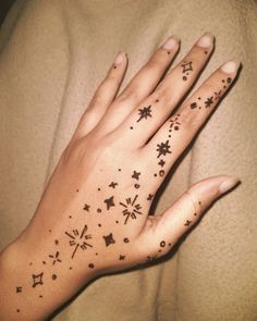 a woman's hand with stars and snowflakes on it