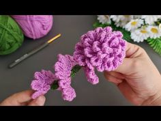 crochet flowers are being held by someone's hand