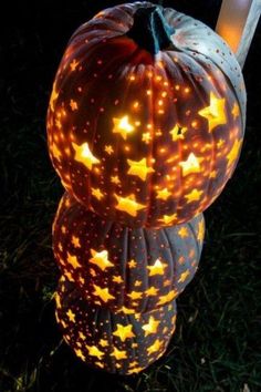 two lighted pumpkins sitting in the grass