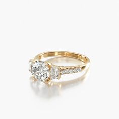 a gold engagement ring with two diamonds on top and side stones in the middle, against a white background