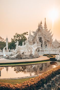 an elaborately designed building sits next to a pond