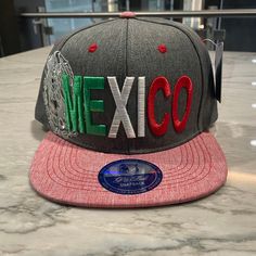 Mexican Eagle (Gray Embroidered Cap w/ Pink Bill) was procured locally right here in Atlanta, Georgia.  We make premium baseball caps representing the places you call home and the lifestyles you love. Our designs are one of a kind unique, adjustable caps. Each product is embroidered unless specified otherwise. Each cap is complete and ready to ship as soon as you make a purchase.  We are an All American Made Apparel Company specializing in authentic baseball caps, tees, sweatshirts, tanks, hoodi Adjustable Gray Hat With Letter Print, Gray Hats With Letter Print And Curved Brim, Gray Flat Bill Baseball Cap With Embroidered Logo, Gray Hat With Letter Print And Curved Brim, Gray Cotton Snapback Hat With Flat Bill, Casual Multicolor Hat With Embroidered Logo, Gray Cotton Flat Brim Baseball Cap, Gray Curved Brim Hat With Letter Print, Adjustable Gray Snapback Fitted Hat