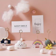 there are many small toy animals on the table next to each other and one is holding a sign that says keep smile