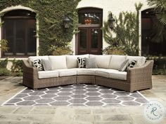 a large sectional couch sitting on top of a rug in front of a building with ivy covered windows