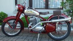 a red motorcycle parked in front of a building