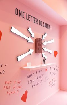 there is a pink wall with writing on it and a clock that says one letter to santa