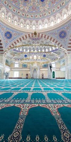 the inside of an ornate building with blue carpet and white walls, decorated in intricate designs