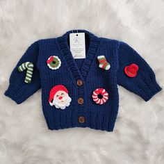 a child's blue sweater with christmas decorations and candy canes on the front