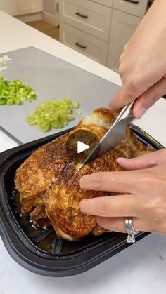 a person cutting up some food on top of a pan with a pair of scissors