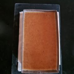 there is a square brown substance in the plastic container