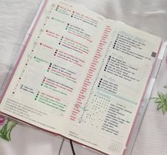 an open planner with pink flowers on the cover and white sheets in front of it