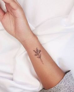 a woman's arm with a small flower tattoo on the left side of her wrist