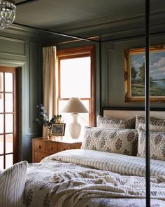 a bedroom with a canopy bed and paintings on the wall