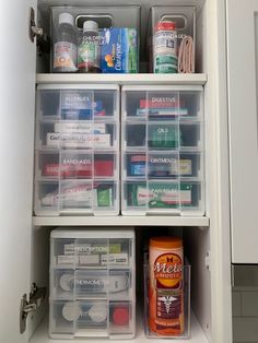 an organized pantry with plastic containers and food items in the bottom shelf, on top of a white cabinet