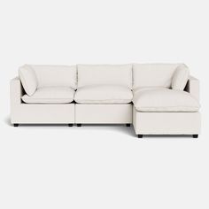 a white sectional couch sitting on top of a white floor