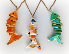 three necklaces with different colored fish on them