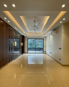 an empty room with a ceiling fan and sliding glass doors