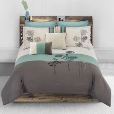 a bed with blue and white pillows on top of it next to a wooden headboard