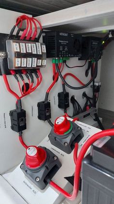 an electrical panel with several different types of wires attached to it and two red lights on each side