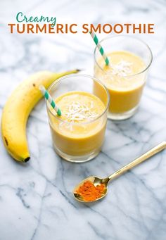 two glasses filled with smoothie and bananas on a marble counter top next to the words creamy turmic smoothie