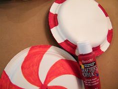 two paper plates with red and white candy canes on them, one has a bottle of glue