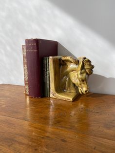 a bookend with a horse head on top of it next to a bookshelf