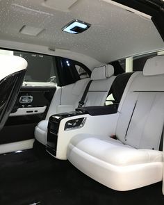 the interior of a luxury vehicle with white leather seats and black trims on it