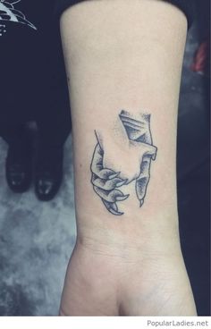 a black and white photo of a wrist tattoo