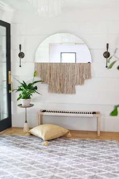 a room with a rug, mirror and potted plant