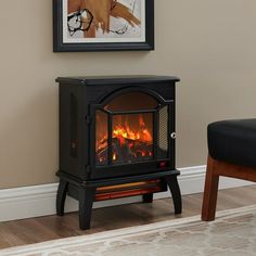 a fireplace with a fire in it next to a chair and painting on the wall