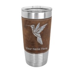 a stainless steel tumbler with a hummingbird on the front and brown leather sleeve