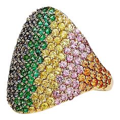 Created in 18 karat yellow gold  Emeralds 0.45 carat approx.  Multicolor sapphires 2.75 carats approx.  Ring size US 7, can be sized up or down  Limited edition    Fashioned from 18k yellow gold, this luxe, limited-edition ring sparkles with a triumvirate of gemstones: a 0.45 carat emerald and 2.75 carats of multicolor sapphires. Its size is a US 7, although can be adjusted accordingly.    About the Designers ~ Dharmesh & Namrata    Drawing inspiration from little things, Dharmesh & Namrata Kothari have created an extraordinary and refreshing collection of luxurious jewels. True believers of destiny, they always feel that the possibilities of design - and life - are limitless when people work together. Formed in 2003, Syna Jewels has grown through enduring relationships with well known, es Multicolor Brilliant Cut Sapphire Ring For Formal Occasions, Luxury Multicolor Sapphire Ring For Formal Occasions, Yellow Multi-stone Sapphire Ring, Luxury Multicolor Sapphire Ring, Luxury Yellow Gold Sapphire Ring With Pave Setting, Luxury Sapphire Ring In Yellow Gold With Pave Setting, Multicolor Brilliant Cut Round Sapphire Ring, Luxury Multicolor Multi-stone Sapphire Ring, Fine Jewelry Multicolor Diamond Ring With Brilliant Cut